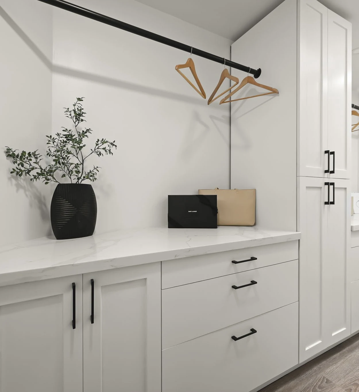White built-in cabinets beneath a large mirror and geometric ceiling light